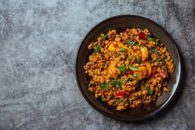 Tayland yemeği malzemeleriyle süslenmiş fesleğen yapraklı kızarmış domuz eti. 