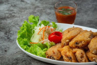 Balık soslu kızarmış kanatlar, güzel süslenmiş otlar ve servis edilen.