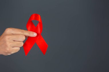 Kadın elinde kırmızı kurdele HIV farkındalığı konsepti Dünya AIDS Günü ve Dünya Cinsel Sağlık Günü.