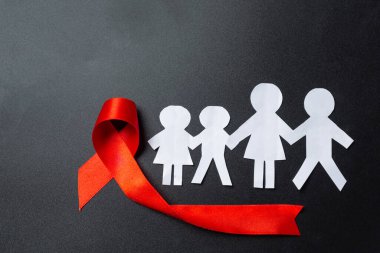 Kırmızı bilgi kurdelesi ve aile kağıt kesimi, HIV farkındalığı, Dünya AIDS Günü ve Dünya Cinsel Sağlık Günü.