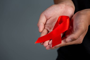 Kadın elinde kırmızı kurdele HIV farkındalığı konsepti Dünya AIDS Günü ve Dünya Cinsel Sağlık Günü.
