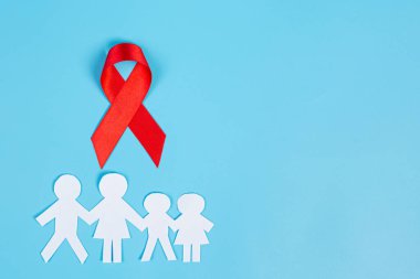 Kırmızı bilgi kurdelesi ve aile kağıt kesimi, HIV farkındalığı, Dünya AIDS Günü ve Dünya Cinsel Sağlık Günü.