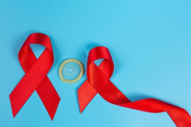 Kırmızı bilgi kurdelesi ve prezervatifler HIV farkındalığı, Dünya AIDS Günü ve Dünya Cinsel Sağlık Günü.