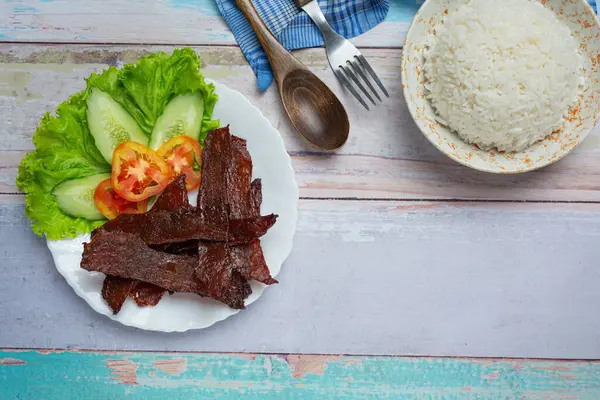 Sun dried beef fried with tomato sauce and steamed rice World food day ideas.