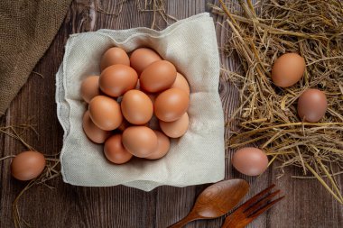 Eggs in cups on burlap with dry grass.
