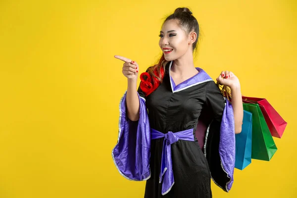 Woman Witch Costume Holding Shopping Bags Yellow Background — Stock fotografie