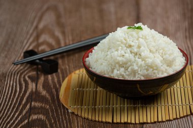 Beyaz pirinç, tahta zemindeki bir fincana konur..