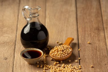 Ahşap zeminde soya sosu ve soya fasulyesi. Soya sosu. Beslenme konsepti..