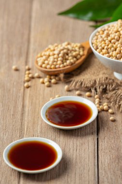 Ahşap zeminde soya sosu ve soya fasulyesi. Soya sosu. Beslenme konsepti..
