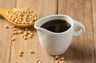 Ahşap zeminde soya sosu ve soya fasulyesi. Soya sosu. Beslenme konsepti..