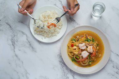 Karışık deniz ürünleriyle kızartılmış, buharda pilav ve Tayland yemeği ile servis edilmiş..