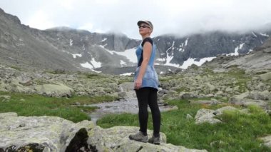 Doğadaki maceralar, dağ yürüyüşündeki genç bir kadın manzaraya hayran. Sibirya.