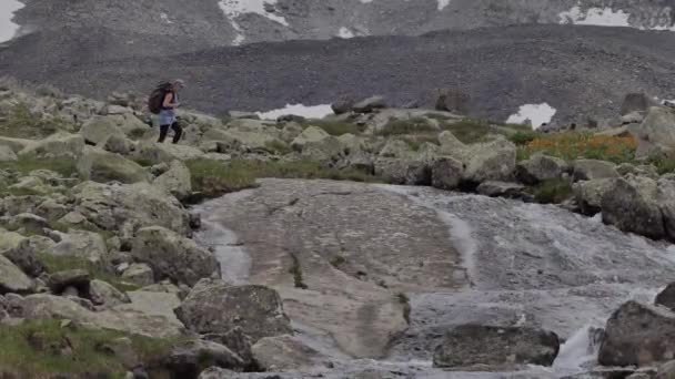 一位背着背包的女游客在一条干净的溪流旁徒步爬山 喝着饮用水 — 图库视频影像