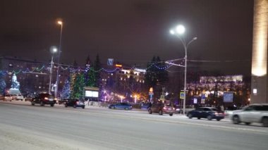 İyi geceler, kış şehri. Şehir tiyatrosu yakınlarındaki karla kaplı bir yolda trafik vardı. Novosibirsk. Sibirya 'da. Noel.