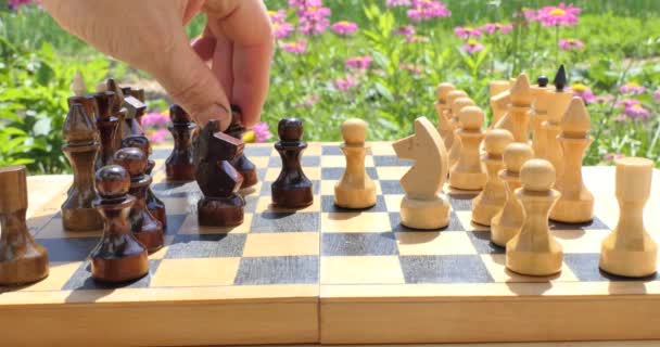 Schack Mans Hand Flyttar Schackpjäs Ett Schackbräde Som Står Sommarträdgård — Stockvideo