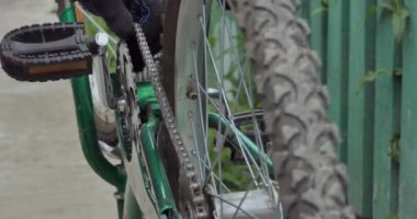 Bisiklet tamiri. Usta motorun ön dişindeki zinciri söker. Yakın çekim..