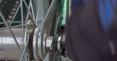 Bisiklet tamiri. Usta tekerleği çıkarmak için bir ingiliz anahtarıyla bisiklet dingilinin vidasını söküyor. Kapat..