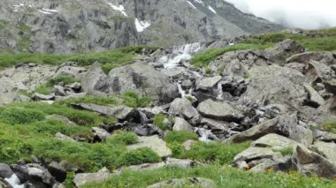 Temiz, doğal su. Dağlarda eriyen bir buzulun oluşturduğu şelale. Sibirya, Altai.