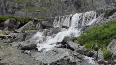 Temiz, doğal su. Dağlarda eriyen bir buzulun oluşturduğu şelale. Sibirya, Altai. Yakınlaştırılıyor.
