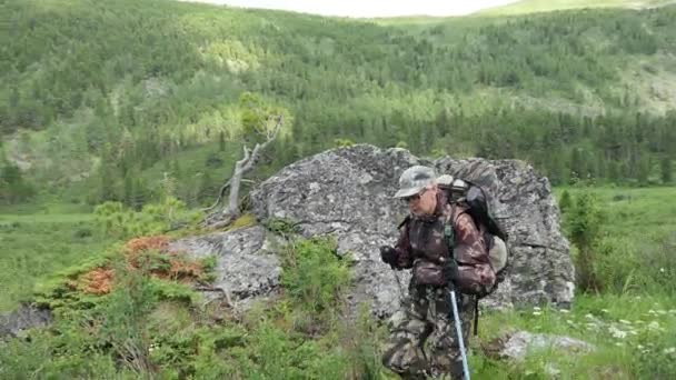 Planten Een Rots Een Vrouw Camouflage Met Een Rugzak Passeert — Stockvideo