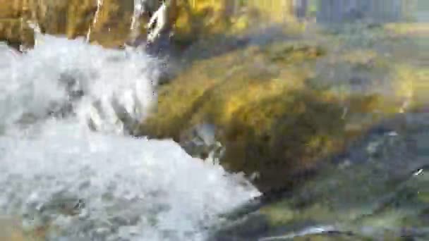 L'écologie. De l'eau. L'eau naturelle pure formée par la fonte du glacier coule dans un ruisseau transparent entre les pierres à la lumière du soleil. Zoomer. Sibérie, Altaï.