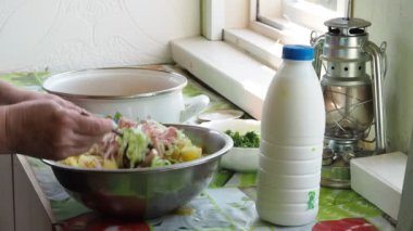 Basit yemek, Asya mutfağı. Aşçı yemeği hazırlamak için süt içeceğini eklemeden önce doğranmış sebzeleri, patatesleri ve pastırmayı bir fincanda karıştırır. Yakın çekim..
