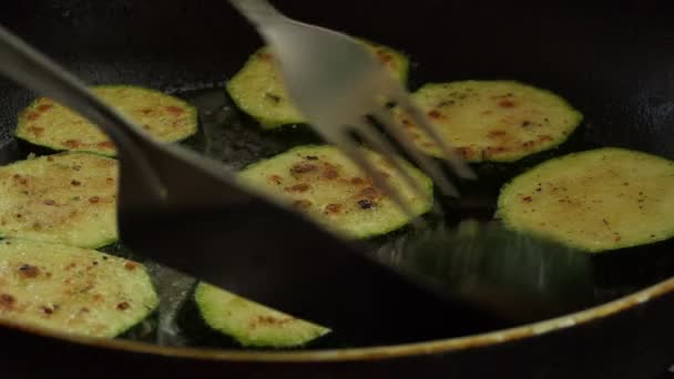 ベジタリアン ビーガン エコフード 料理のローストと野菜油で鍋にスパイスと混合小麦粉で覆われたズッキーニの作品を裏返し — ストック動画