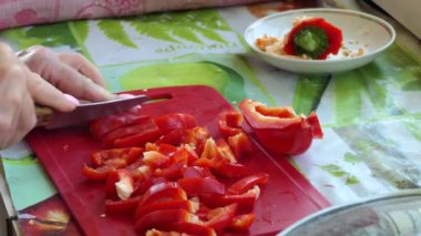 Vegan, Asya mutfağı. Basit bir yemek. Aşçı pişirmek için bir bıçakla doğrama tahtasındaki biber dilimlerini keser..