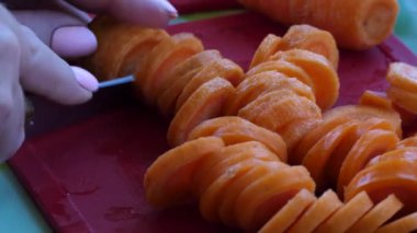 Vejetaryen, basit yemekler, sebzeler. Aşçı kesme tahtasındaki bıçakla havuçları daire içine alır. Kapat..