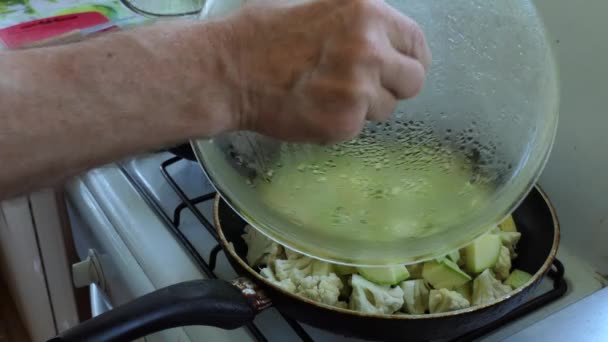 アジア料理 シンプルな料理 料理人は 鶏や野菜の破片が揚げられている鍋からカバーを削除し ナイフでそれを貫通することによって鶏の準備を確認します — ストック動画