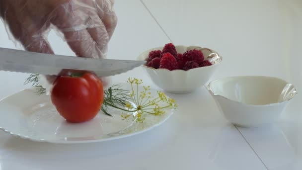オーガニック ビーガン エコプロダクト 料理人は白い皿の上にトマトを切る 閉じろ — ストック動画