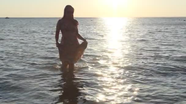 日落时在海滩上的女孩 日落时分 一个穿着漂亮衣服的姑娘穿过阳光小径 从水里走了出来 西伯利亚的奥布河慢动作 — 图库视频影像