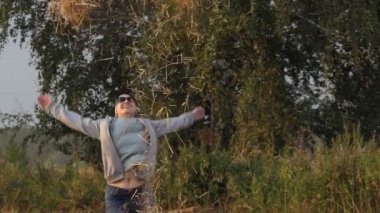 Bir kadın tarlaya saman yığını atıyor. Yavaş çekim.