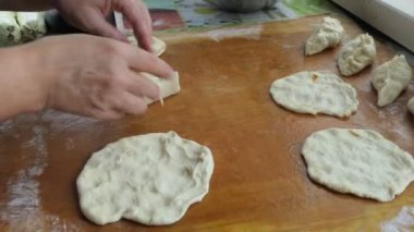 Vejetaryenlik, basit yemekler, Asya mutfağı. Bir kadın hamurdan yapılmış bir kesme tahtasında lahana turtası için bardak hazırlıyor. Yakın çekim..