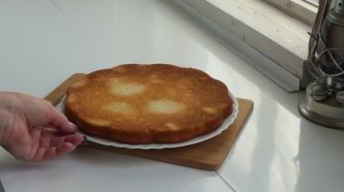 Vejetaryenlik, turta pişirme. Bir kadının eli, tabağındaki bitmiş turtayı çevirir. Yakın çekim..