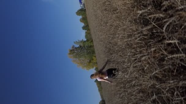 一个年轻而快乐的女人跑过麦田 慢动作 相机旋转 — 图库视频影像