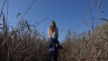 Anne ve çocuk. Genç ve mutlu bir anne, Sibirya 'da bir buğday tarlasında küçük bir çocukla yürüyor. Kamera hareket ediyor..