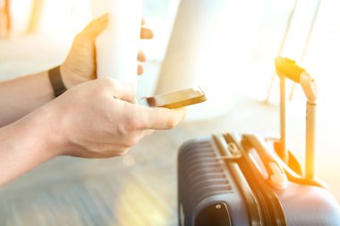 Havaalanında bekleyen yolcular / mobil telefon ve içecek kahve kullanarak yolcu