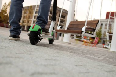 Bir adamın bir elektrikli scooter üzerinde görüntü kadar kapatın.