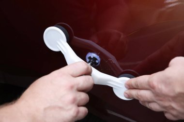 Adam tek başına araba göçüğü tamir ediyor.