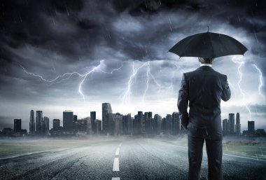 Businessman With Umbrella Looking Storm Over City clipart