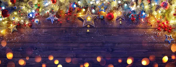 Çam dalları ve koyu ahşap tahta ışıkları ile Noel süs