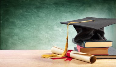 Mezuniyet Cap ve Kitaplar Ile masa üzerinde diploma