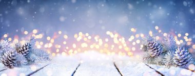 Karlı Masa ve Noel Işıklarında Çam kozalakları ve Dalları
