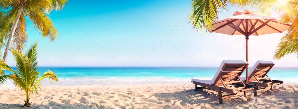 Deckchairs And Parasol With Palm Trees In The Tropical Beach