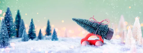 Červené Auto Nesoucí Vánoční Strom Rozostřené Zasněžené Krajině — Stock fotografie