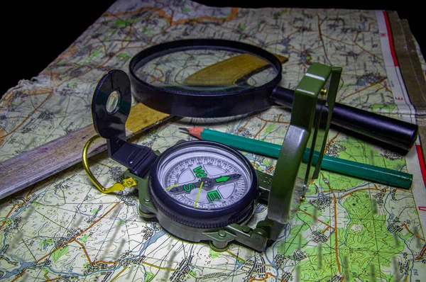 Sony Compass and map for orientation on the terrain, accessories for plotting the route, photographed in the studio from above and horizontally.