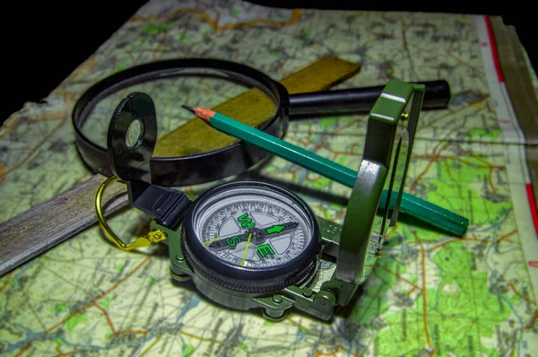 Sony Compass and map for orientation on the terrain, accessories for plotting the route, photographed in the studio from above and horizontally.