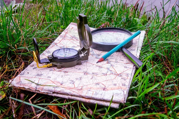 Ukraine, compass and map for travel navigation, photographed in natural light, in the early morning with lateral sunlight.