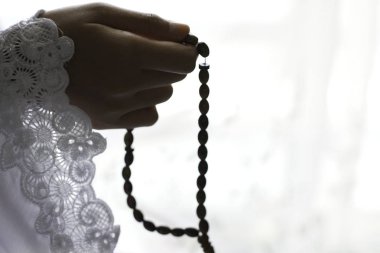 dua boncuktutan kişinin kısmi görünümü, İslam dini ve tespih boncuk
